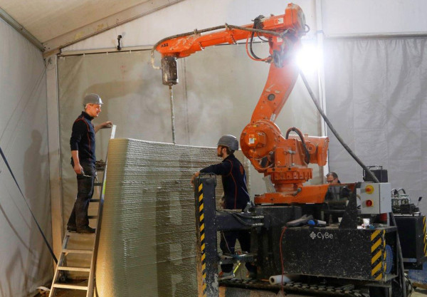 Machineprinting concrete whilst workers look on